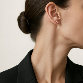 A pair of 18K yellow gold earrings featuring round-cut white diamonds arranged in a sparkling, star-like pattern.